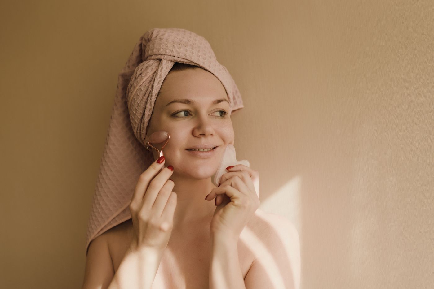 Mujer cuidando su piel con un rodillo facial